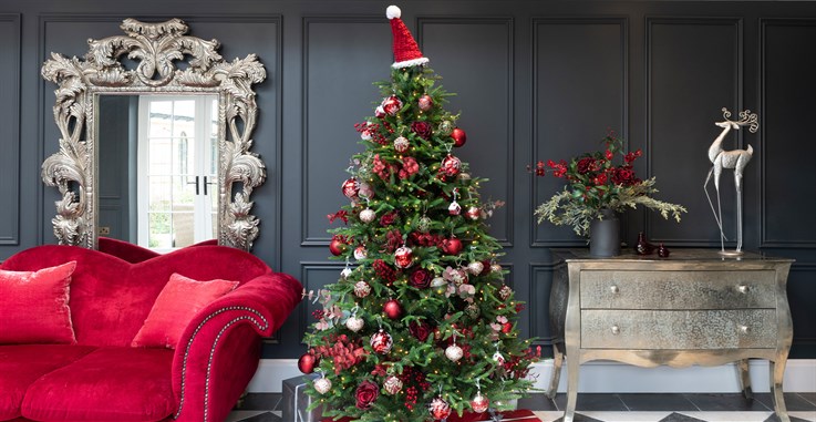 white, silver and red christmas tree with red sofa, large ornate silver mirror and matching floral arrangement