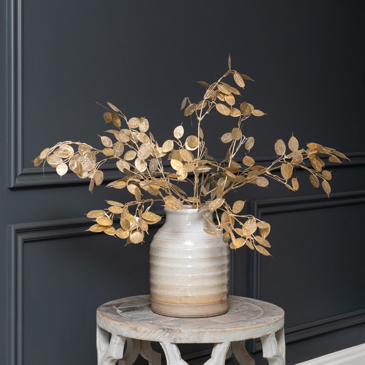 gold metallic foliage stems in a vase on a small table