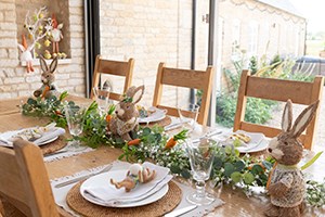 easter themed table display with rabbit decorations and garland