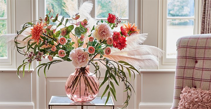 pink artificial flower and pampas arrangement in pink glass vase
