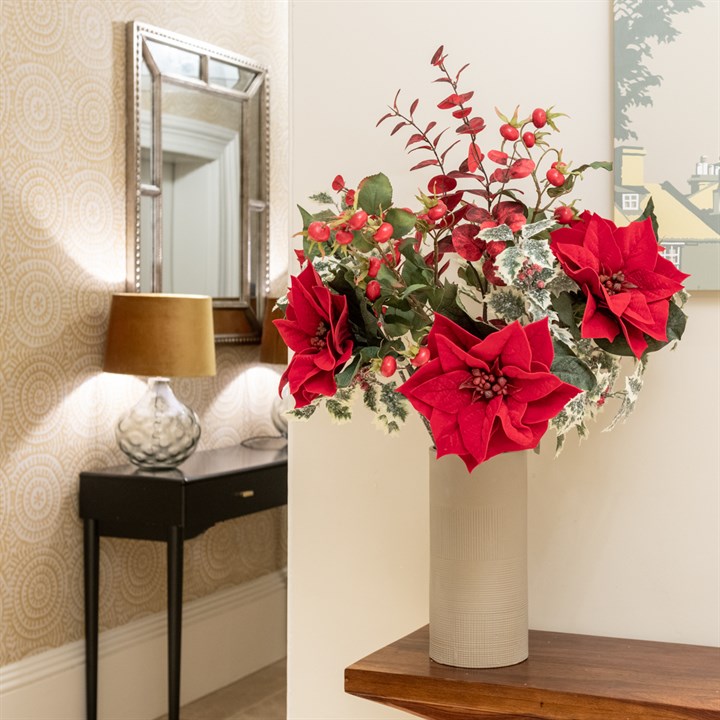 red artificial poinsettias with eucalytus and other foliage in tall vase 