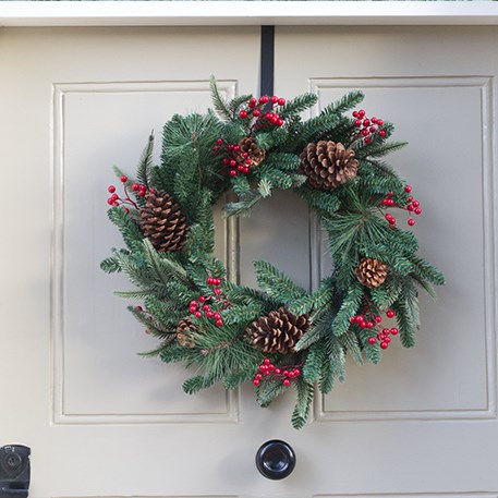green christmas wreath with berries on front door