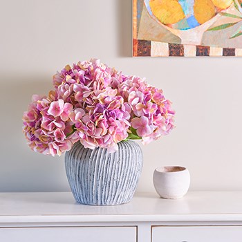 pink artificial hydrangeas in globe vase 