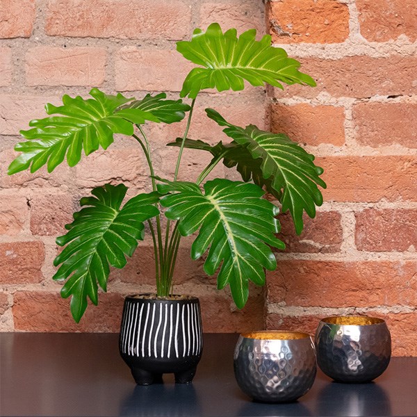 artificial potted plant against brick wall