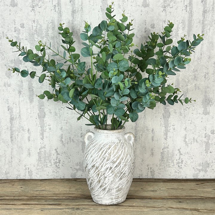 A vase of artificial eucalyptus in its classic green colour
