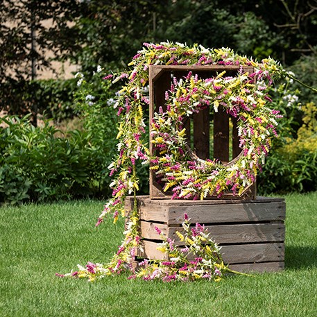 faux floral wreaths and garlands on stack of crates