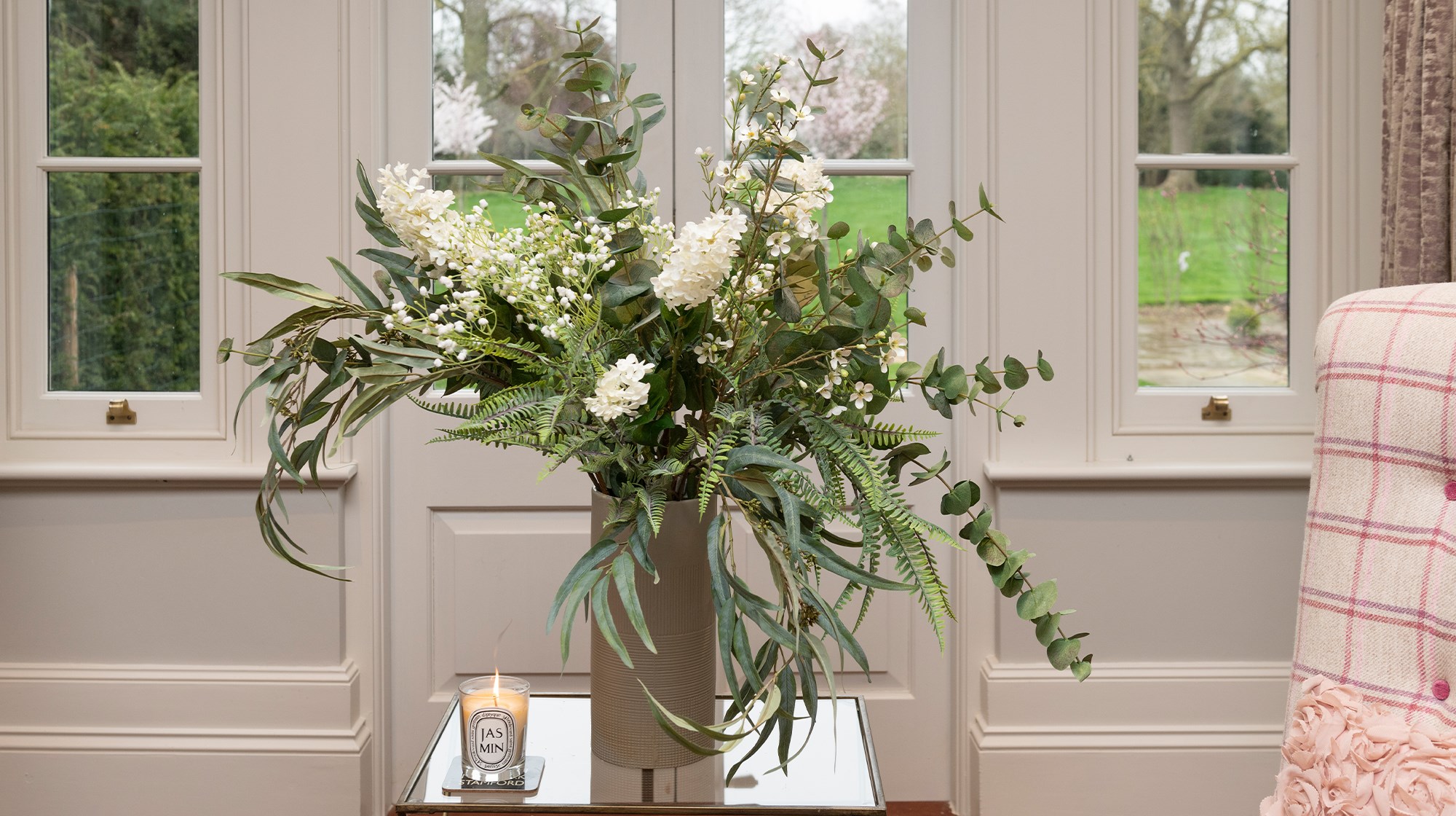 artificial eucalyptus and other green faux foliage in tall vase