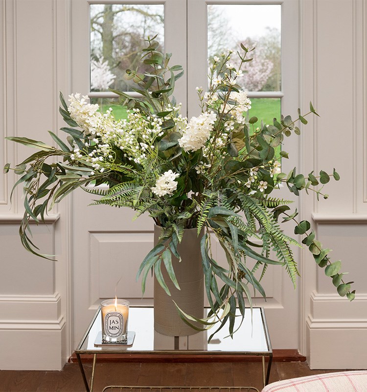 artificial foliage arrangement in tall vase