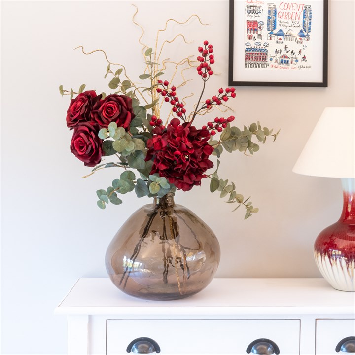red berries, hyndrangeas and roses arranged with eucalyptus in recycled orb vase