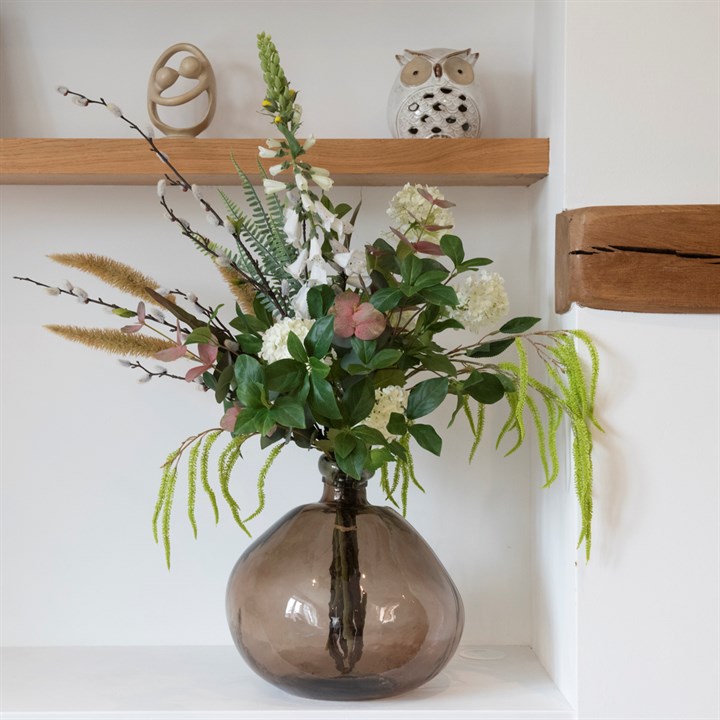 artificial foliage bouquet in glass vase