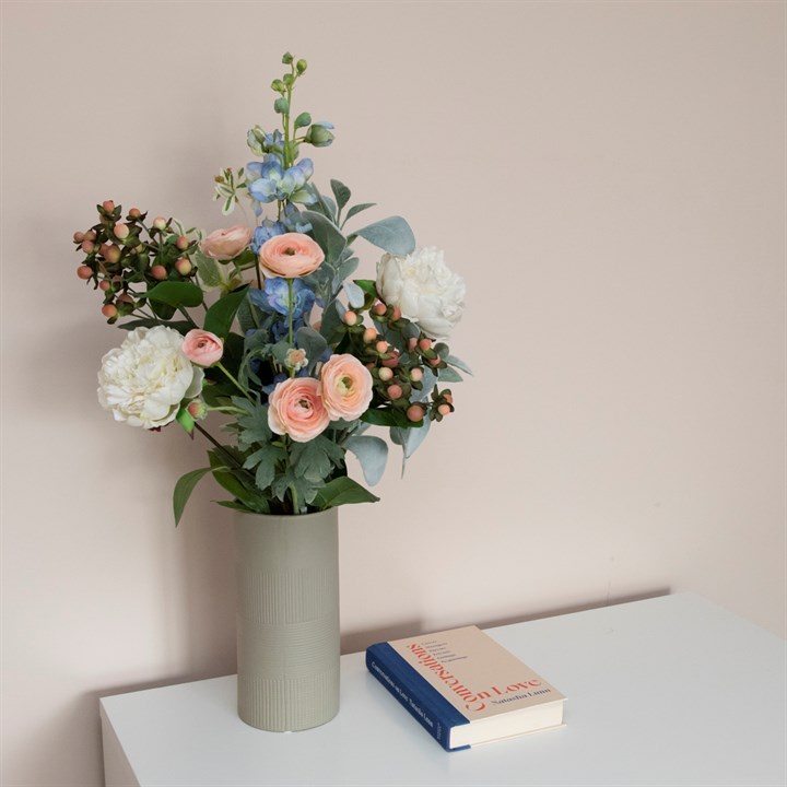 artificial ranunculus and euphorbia stems arranged in vase