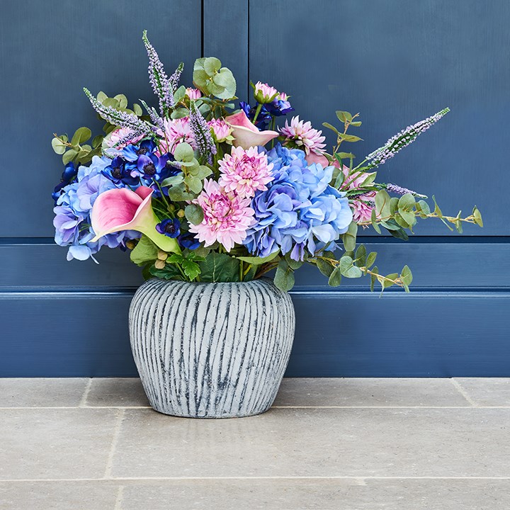 blue and pink faux flowers in globe vase