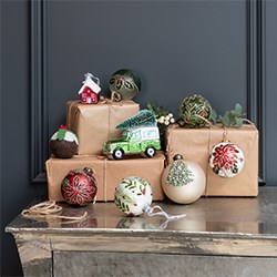 christmas decorations and baubles on top of presents wrapped in brown paper