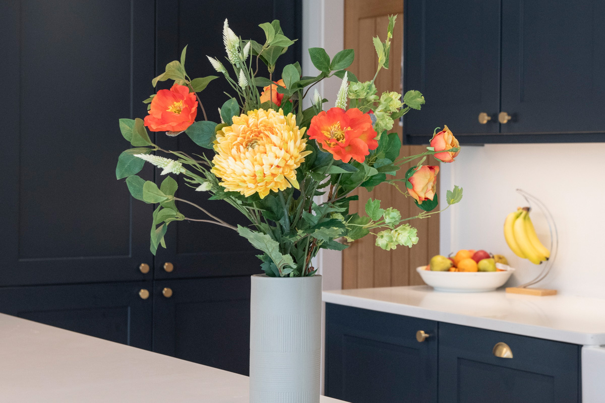 faux orange and yellow flowers arranged in vase